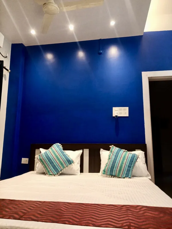 Simolu Suite double bed with striped cushions against a blue wall